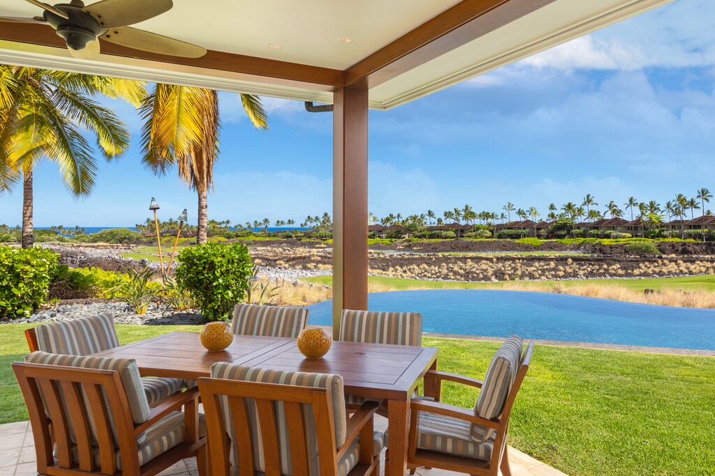 Lanai seating with views of the golf course and ocean beyond—ideal for relaxing or gathering with loved ones.