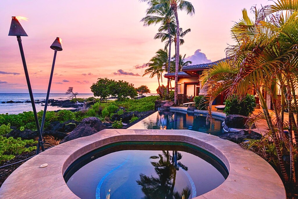 Unwind in the hot tub under swaying palms with dramatic evening skies in the background.