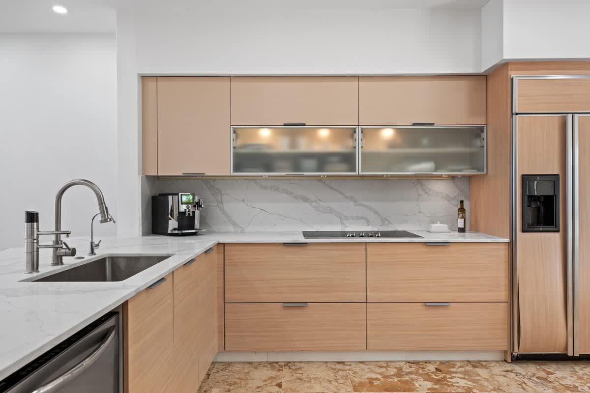 Natural wood cupboards and cabinets; Sub-Zero, double-door refrigerator with Ice maker
