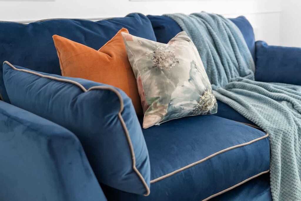 Unwind in this beautifully designed living space, featuring plush blue sofas, elegant decor, and a bright bay window overlooking lush greenery. Perfect for relaxing after a day of exploring! 