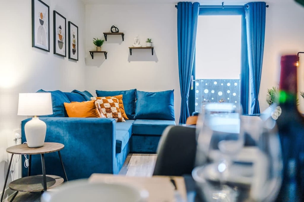 The open-plan living room and dining area benefit from a 50-inch Smart TV, a 6-seater dining table, plenty of space to sit down in the evenings, a double sofa bed and a sizable balcony.