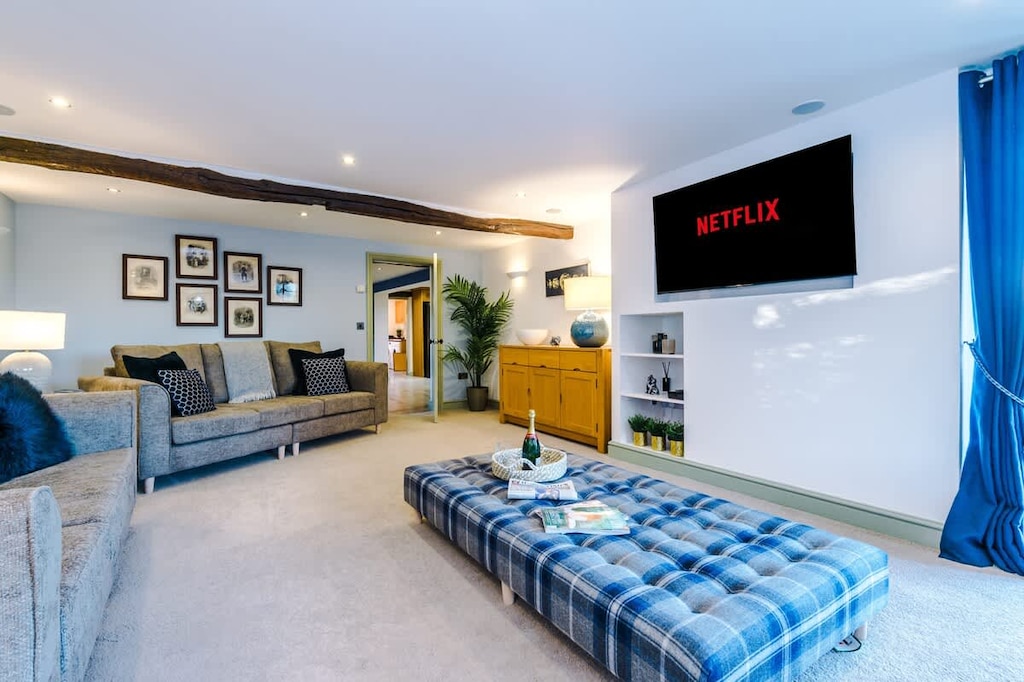 The spacious living room benefits from a 55-inch SMART TV with Netflix on the wall, plenty of space to sit down with family and friends in the evening, and a gorgeous log burner to keep warm in the evenings.