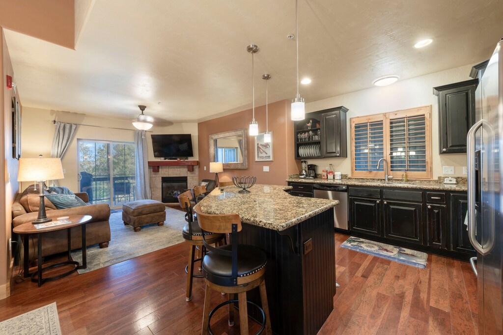 Kitchen offers granite counters, hardwood floors, and comfortable dining space