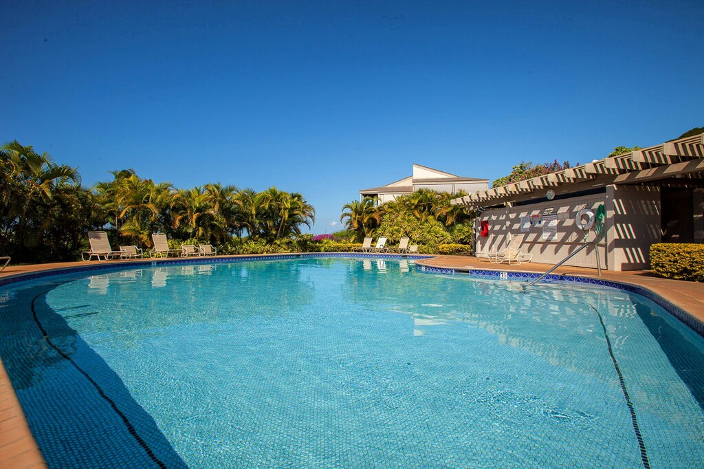 Large resort-style pool with expansive sun deck and tropical surroundings.