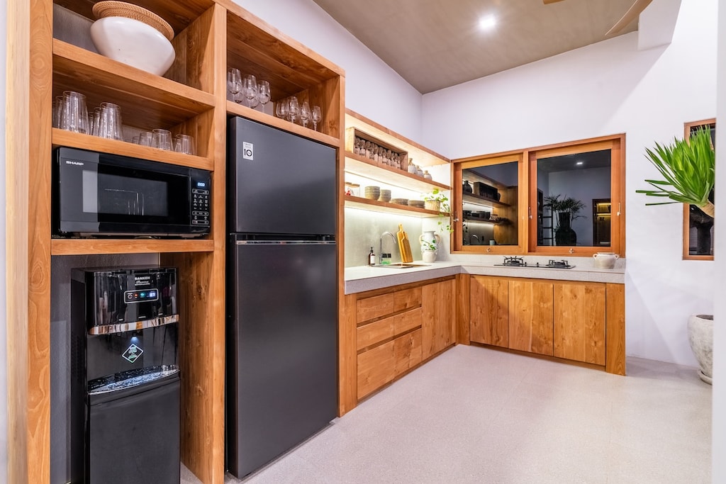 Kitchen with integrated appliances, ample storage, and a clean, airy feel. #Villa Samalas