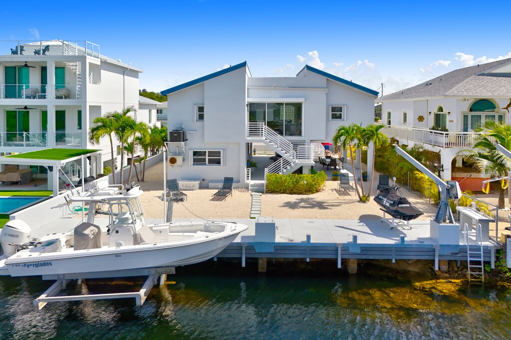 Backyard | Private boat dock offers direct ocean access, with lounge chairs positioned for soaking up the breeze or enjoying the waterfront view.