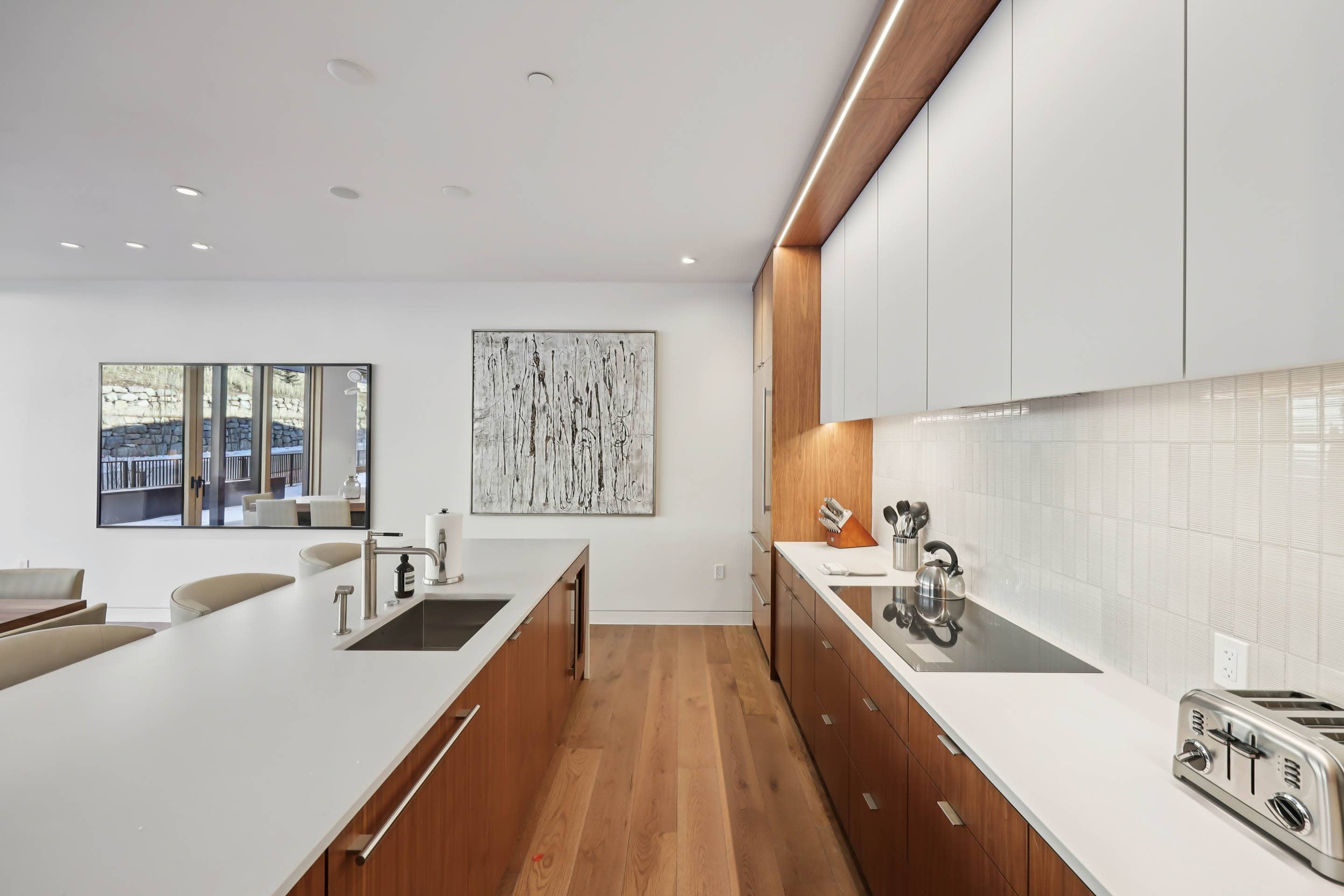 Step into your sleek modern kitchen with warm wood cabinetry, pristine white countertops, and premium appliances ready for your culinary adventures.