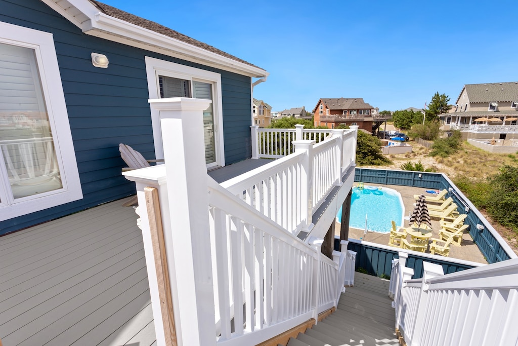 A large fenced-in pool deck area features an inviting private pool and plenty of chairs and pool loungers to make tanning poolside a breeze.