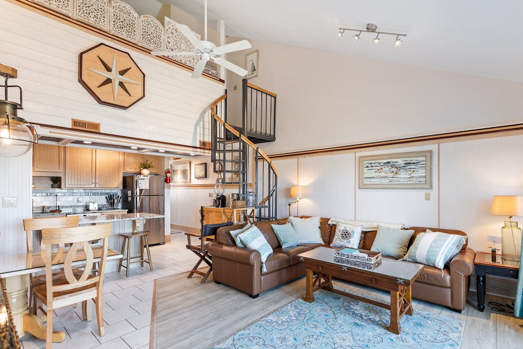 The open-concept Main Level boasts a cozy Living Area with high ceilings, a large Flat Screen TV, and a wall with windows and glass sliders overlooking the Pamlico Sound!