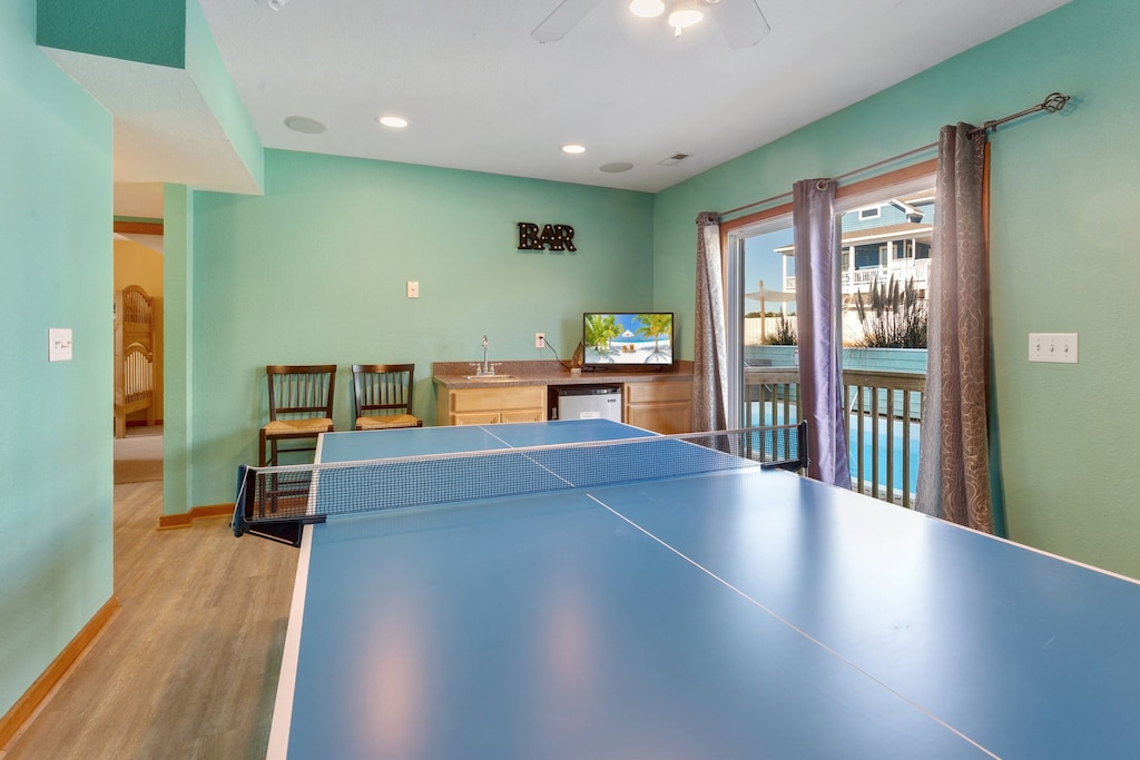 The ping pong table in the ground-level recreation room with a wet bar & flat-screen TV is the perfect opportunity for more friendly competition.