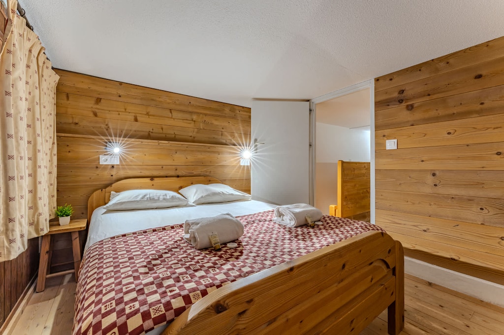 Rustic charm meets comfort in this double room with warm wood paneling and soft lighting.