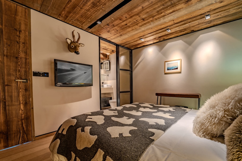 Peaceful and stylish bedroom in Megève with soft lighting and natural textures. A restful retreat after a day exploring the slopes or wandering through the village center.