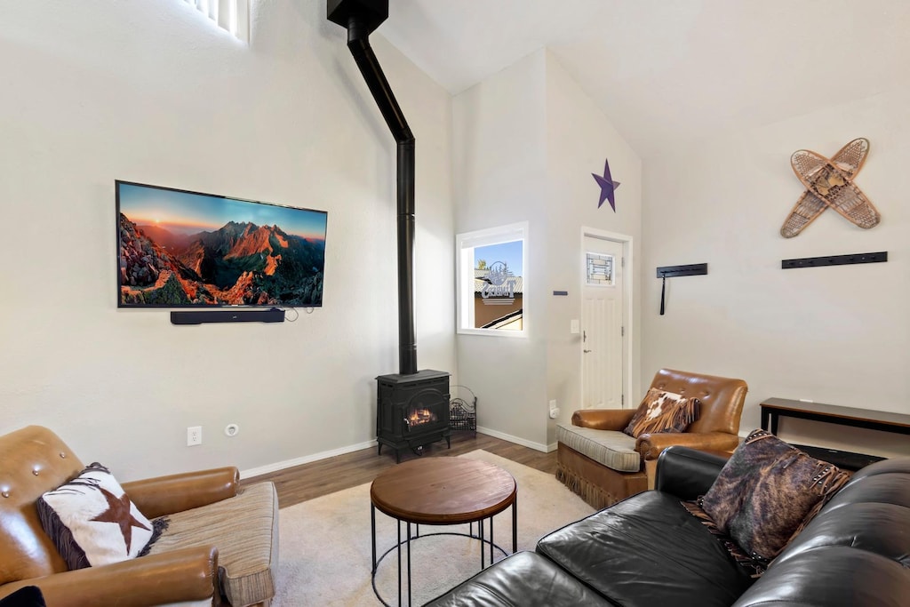 Main living room with gas fireplace, smart TV that is open to the kitchen and dining room. 