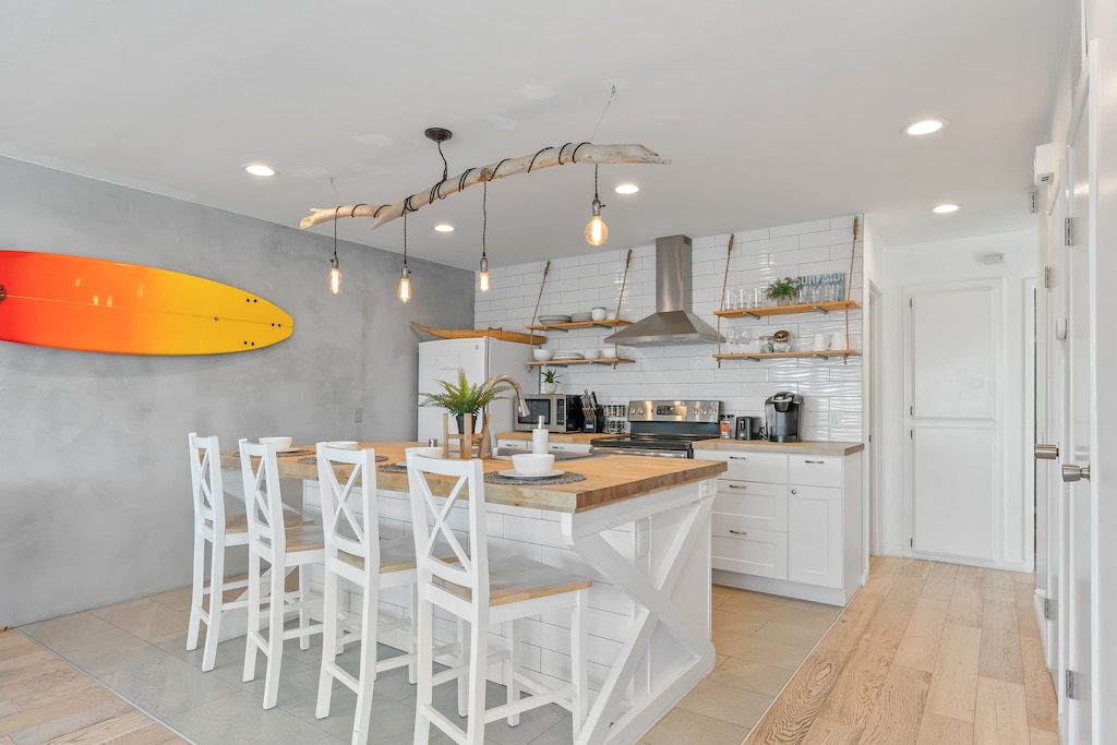 Modern kitchen with barstool seating and pendant lighting.