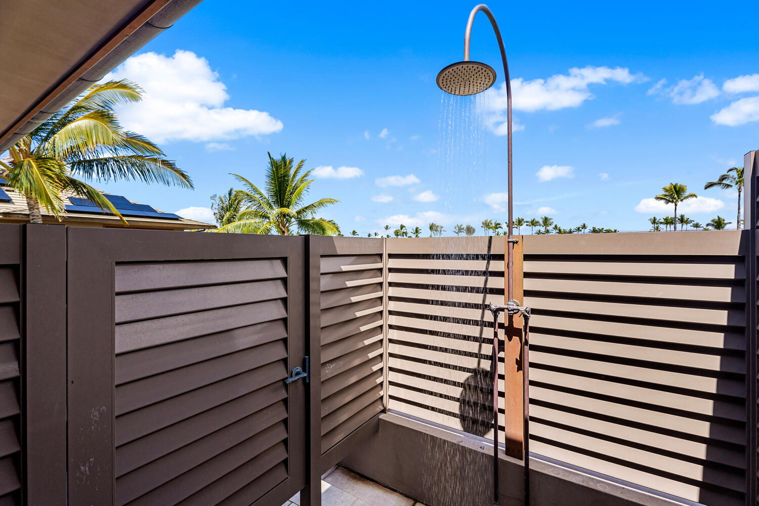 Rinse off under the private outdoor shower surrounded by tropical palms.