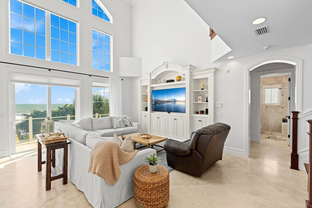 Bright living room featuring high ceilings with lots of natural light & a stunning oceanfront view!