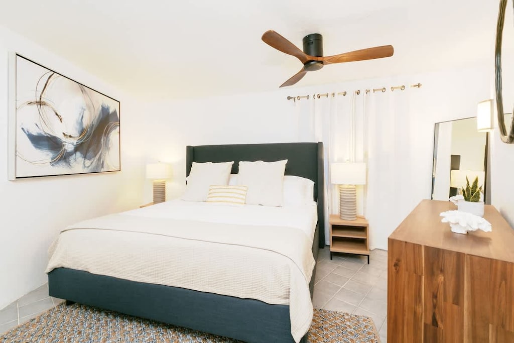Cozy bedroom w/ stylish décor, plush bed & ample natural light. Rest easy in your secluded retreat!