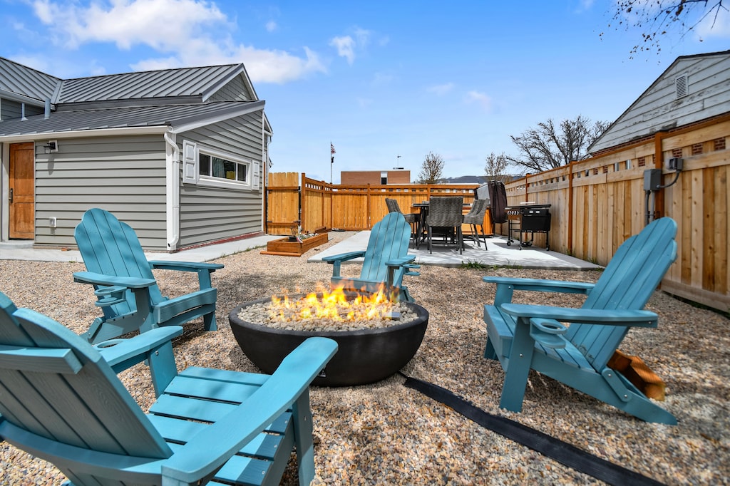 The large backyard is fully landscaped with Firepit, Adirondack Chairs, Hot Tub, Blackstone BBQ Grill, and Outdoor Dining table