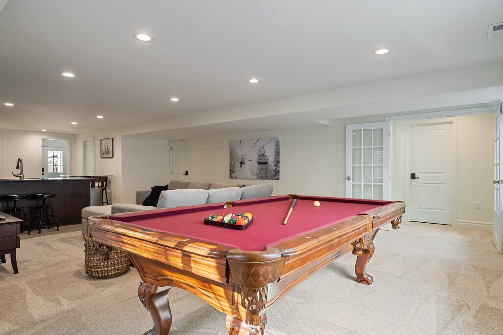 The downstairs family room has a classic pool table, large sectional, 2nd full kitchen and large smart TV