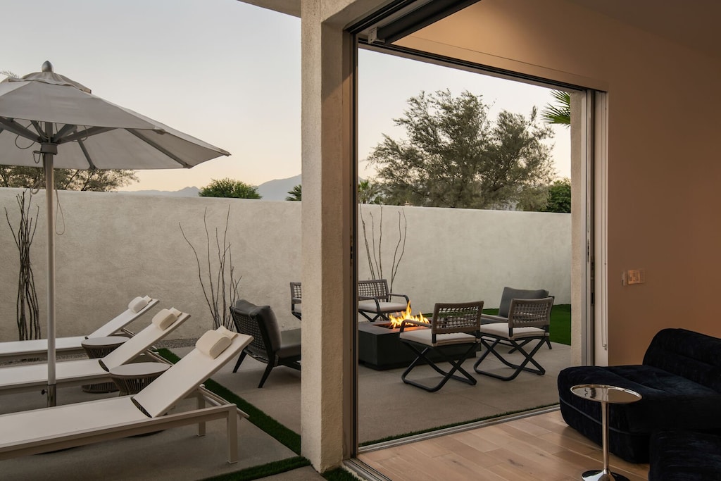 Cozy up at sunset around the outdoor fire pit and comfortable seating, with views of the mountains and the main pool area.