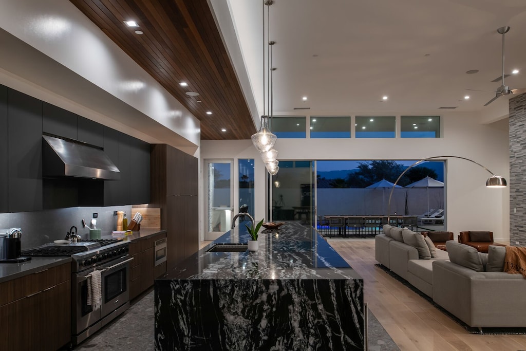 Experience true indoor-outdoor living at twilight, with the living area, gourmet kitchen, and bar seamlessly flowing to the illuminated pool deck.