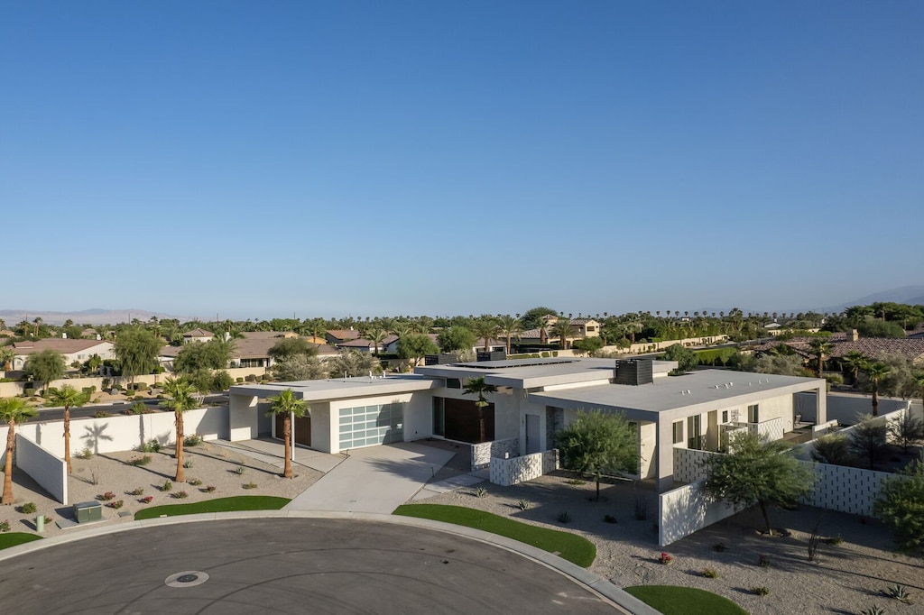A wide shot of the home's contemporary facade and the surrounding desert landscape under a clear blue sky.