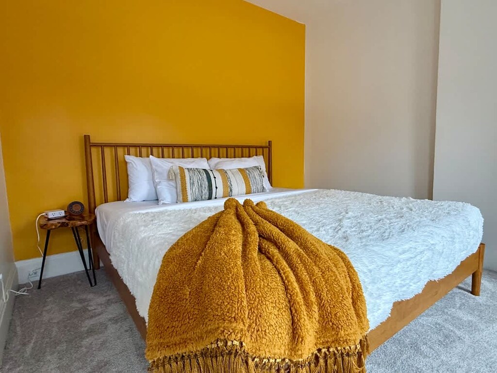 "& Drift into serenity in our cozy Jungle House bedroom in Columbus! Our plush bed with a white comforter, black decorative pillow, and wooden headboard ensures a restful night’s sleep. & Our plants are looking forward to hosting you soon  Book y