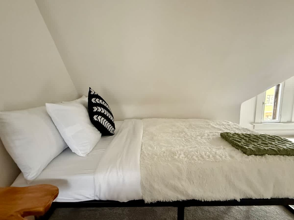 "Experience the elegance of our modern bedroom at Jungle House Airbnb complete with a sleek wooden vanity and cozy ambiance  Your perfect retreat in Short North Columbus