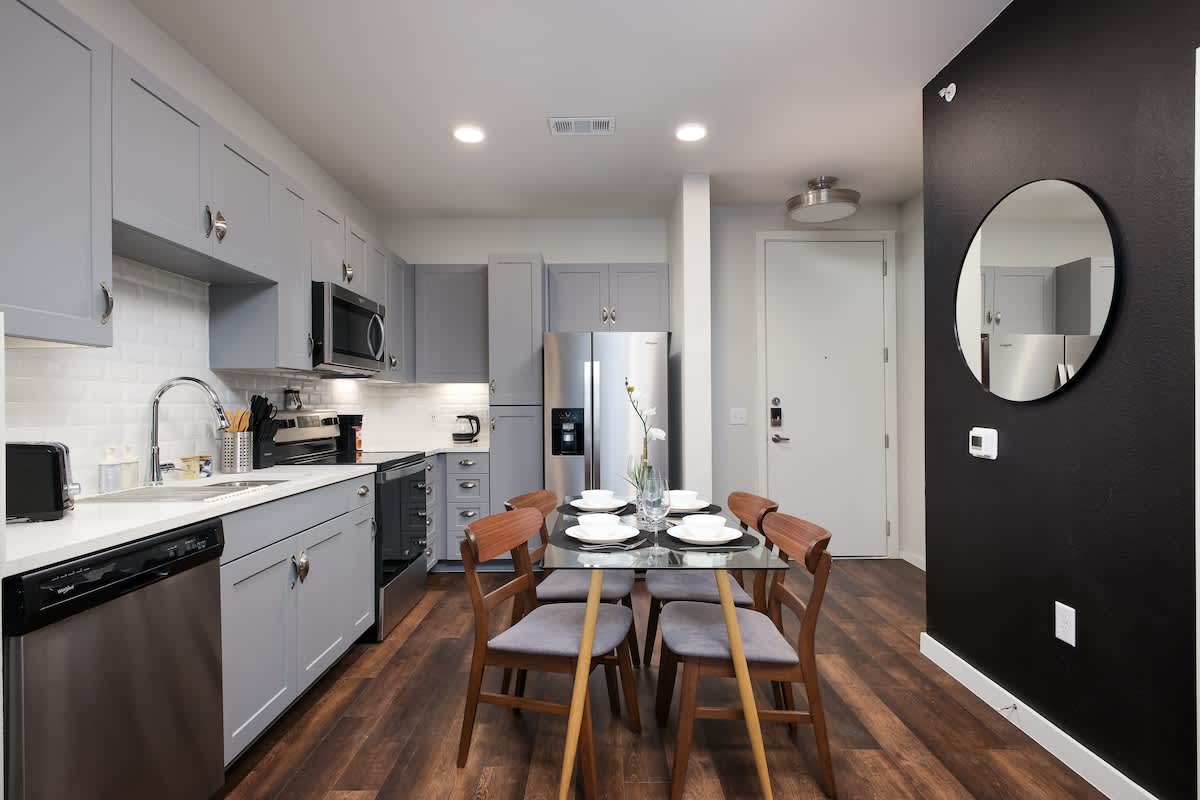 Dine in a peaceful atmosphere, enhanced by a white orchid centerpiece and a circular mirror.