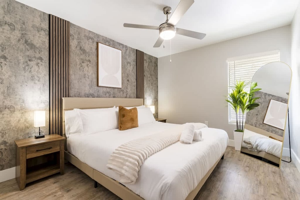 Bright and cozy bedroom retreat featuring a king-sized bed, modern textured accent wall, and stylish decor for restful comfort