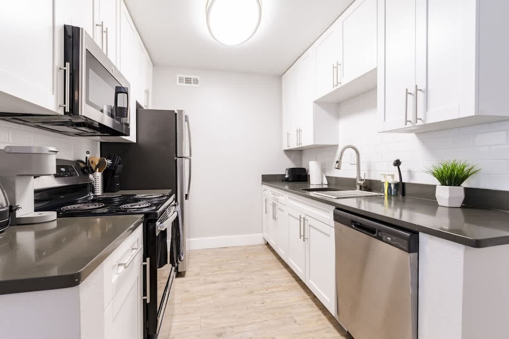 Modern galley-style kitchen with full-size stainless steel appliances, elegant finishes and everything you need for home-cooked meals