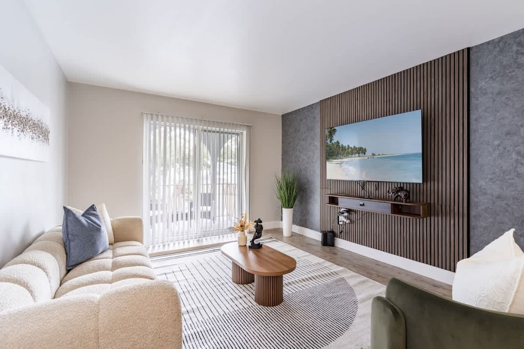 The perfect place to relax and unwind featuring a stylish living room with natural light, smart TV, and elegant decor. Where comfort meets style