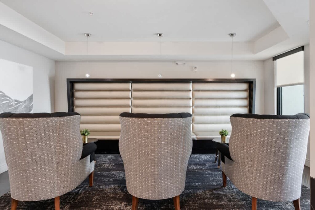 Unwind in a cozy living room with tree plants, soft sofas, and a TV for your entertainment.