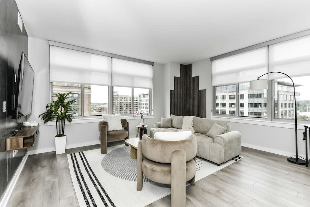 Chic and bright living room with cozy couch, flatscreen Tv and dedicated work station