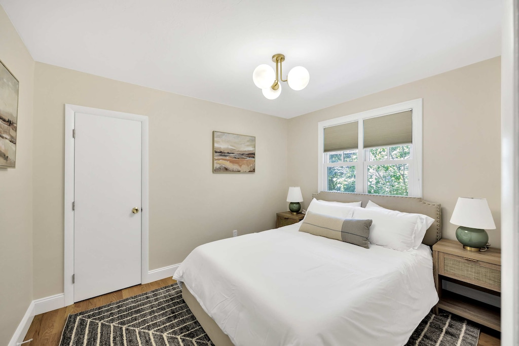 Cozy bedroom with room darkening shades and a peaceful view of the trees beyond.