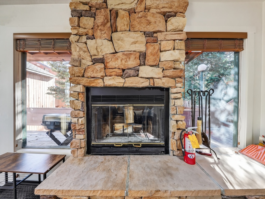 Gather around this stunning stone fireplace where crackling flames meet mountain views through panoramic windows—your perfect retreat for cozy evenings with loved ones.