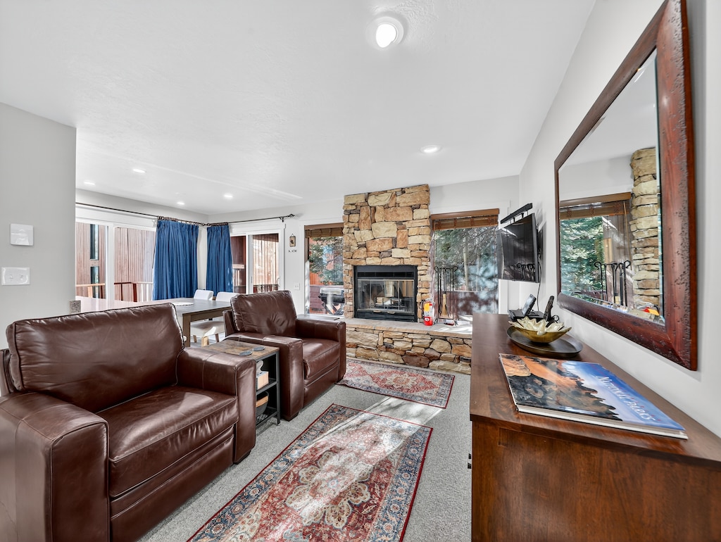Unwind in your spacious living room where rich leather seating faces a stunning stone fireplace. Watch the flames dance while you relax on comfortable sofas, enjoying mountain views through expansive windows.