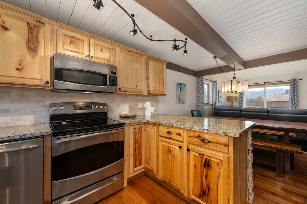 Your fully equipped kitchen features rustic wood cabinets, granite counters, and modern appliances for memorable home-cooked meals.