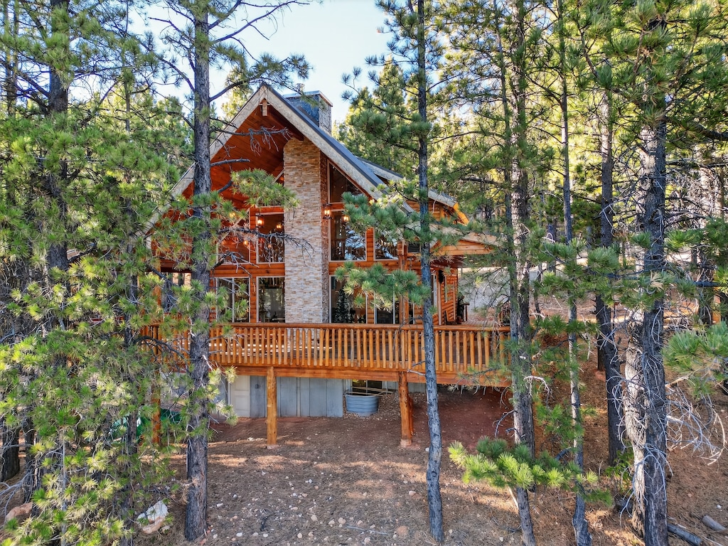 Escape to your own private forest retreat where towering pines frame this stunning mountain cabin. Relax on the spacious wraparound deck and breathe in the crisp woodland air.