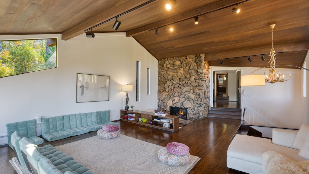 Gather around the stunning floor-to-ceiling stone fireplace under a dramatic vaulted ceiling. The perfect blend of Sonoma style and mid-century warmth.