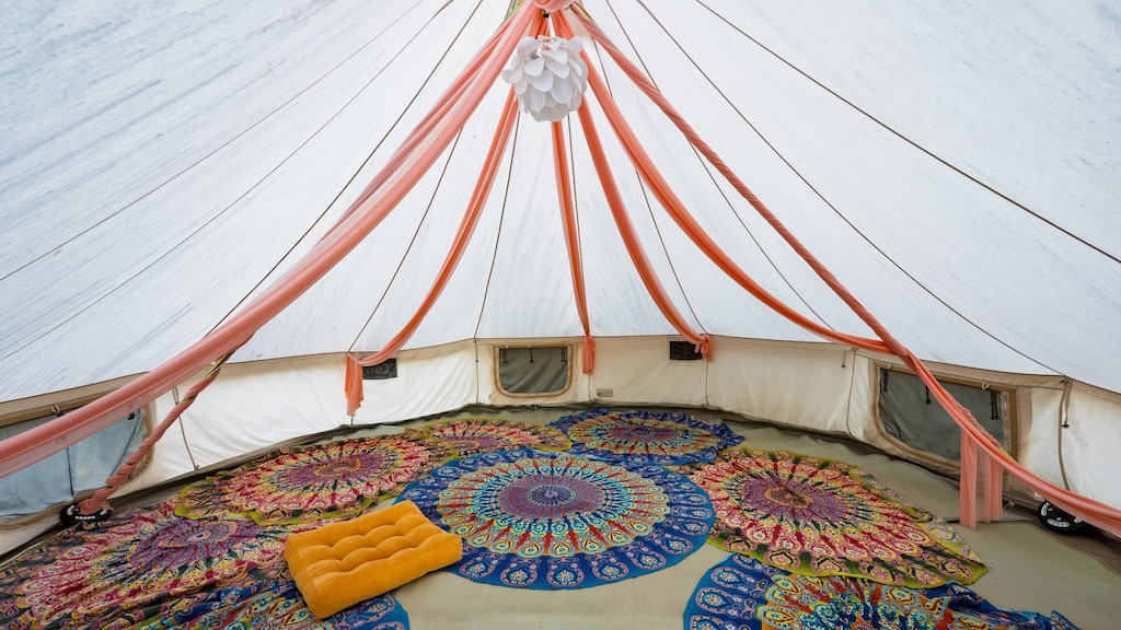 Relax inside this spacious, boho-style tent set in a serene natural landscape.