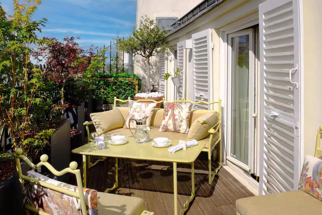 Une terrasse fleurie baignée de soleil, idéale pour vos petits-déjeuners en plein air ou vos soirées paisibles au cœur de Paris.
