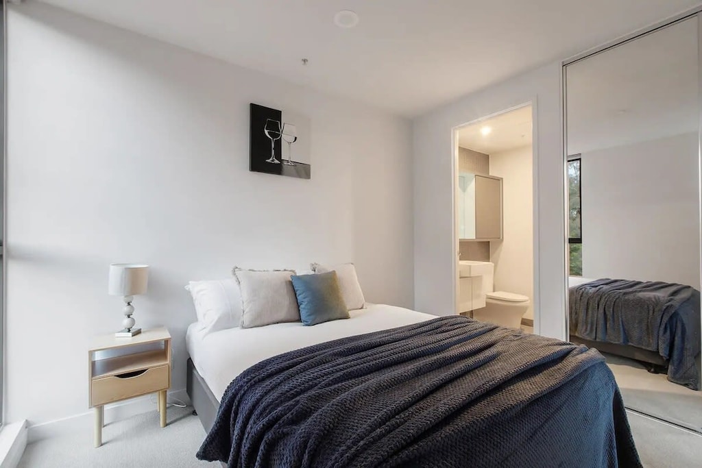 The master bedroom with a queen-sized bed, plush pillows.