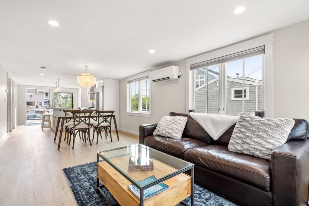 Fully equipped open kitchen and living room with large island, high-end appliances, kitchen table, washer/dryer, smart tv