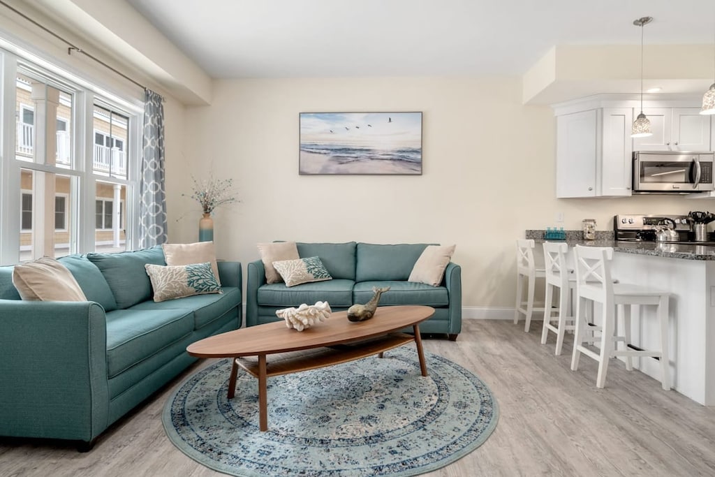 Open living room & kitchen with sleeper sofa, mounted smart TV, strong WiFi and fully-equipped kitchen