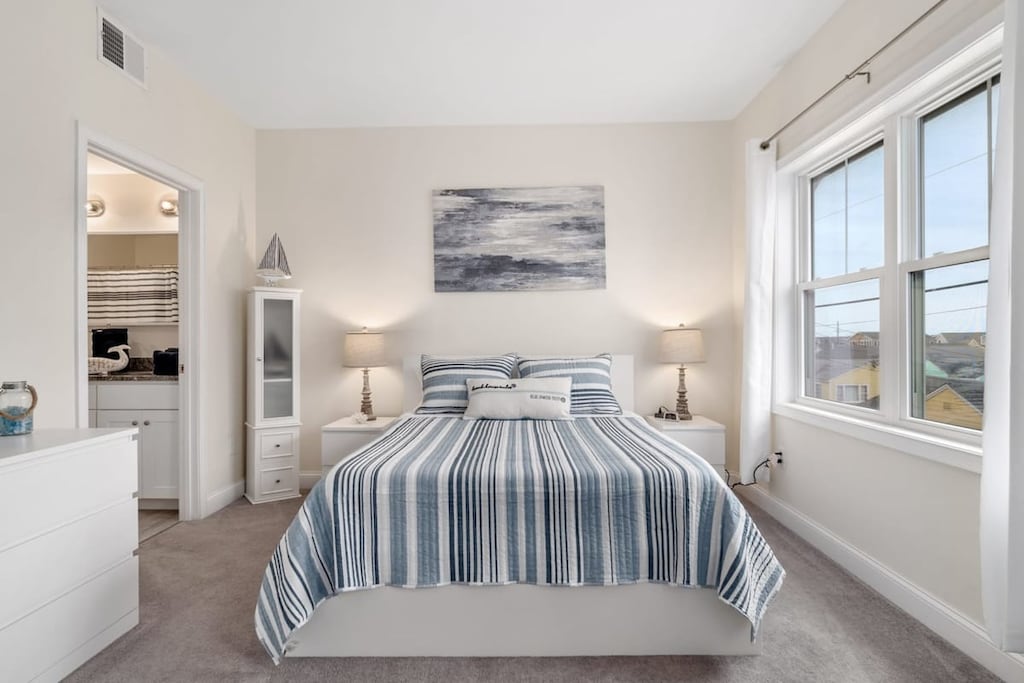 Bedroom with ensuite bathroom with double sink, stand up shower and stackable washer & dryer