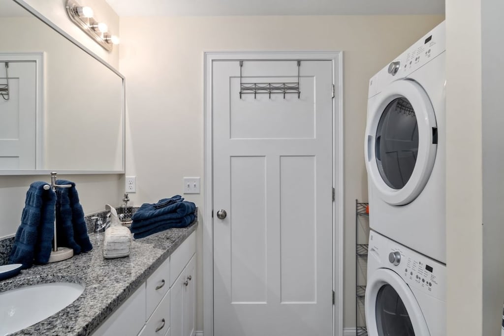 Bedroom with ensuite bathroom with double sink, stand up shower and stackable washer & dryer