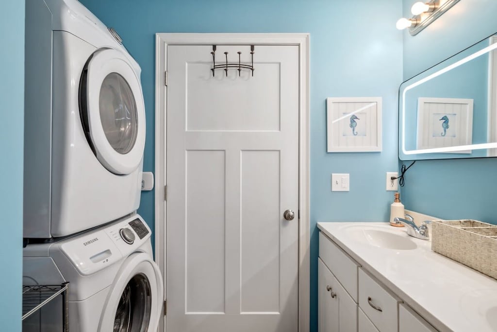 bedroom with ensuite bathroom with double sink, stand up shower and stackable washer & dryer