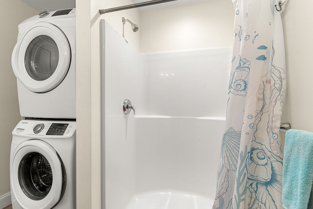 En-suite primary bathroom with double vanity sink, stand up shower and washer/dryer