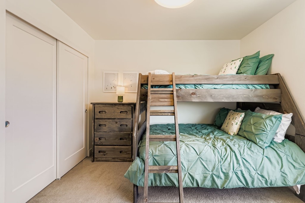 Cozy bunk beds with soft sage linens create the perfect kids' retreat, complete with built-in storage for all your family's belongings.